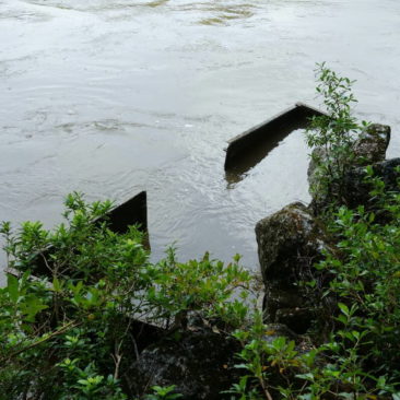 Das fast vollständig im Hochwasser führenden Fluss versunkene Eisenbahnwrack nahe Westport